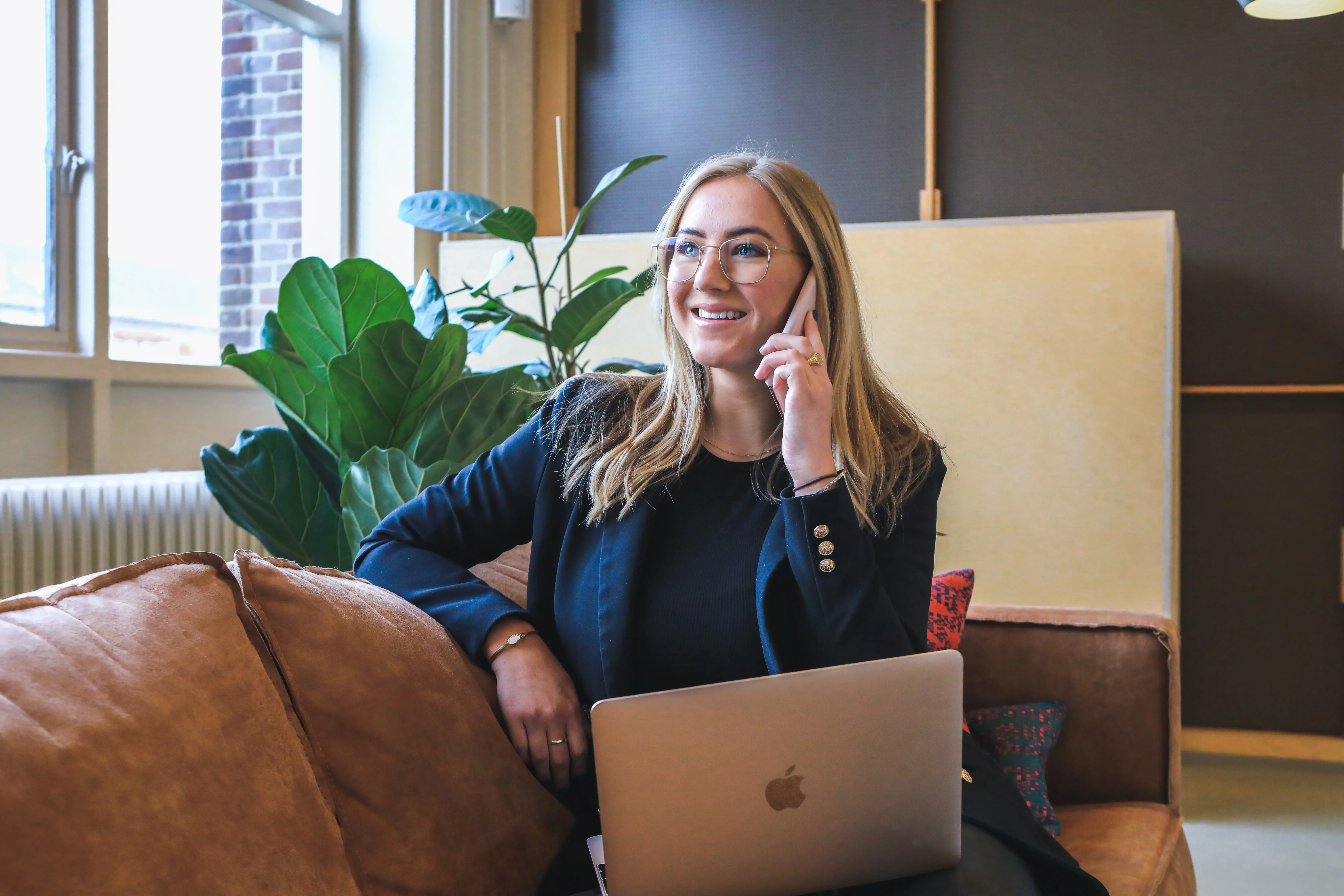 businesswoman sat smiling whilst making a phone call