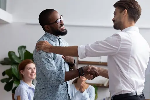 An image of two people in the workplace shaking hands